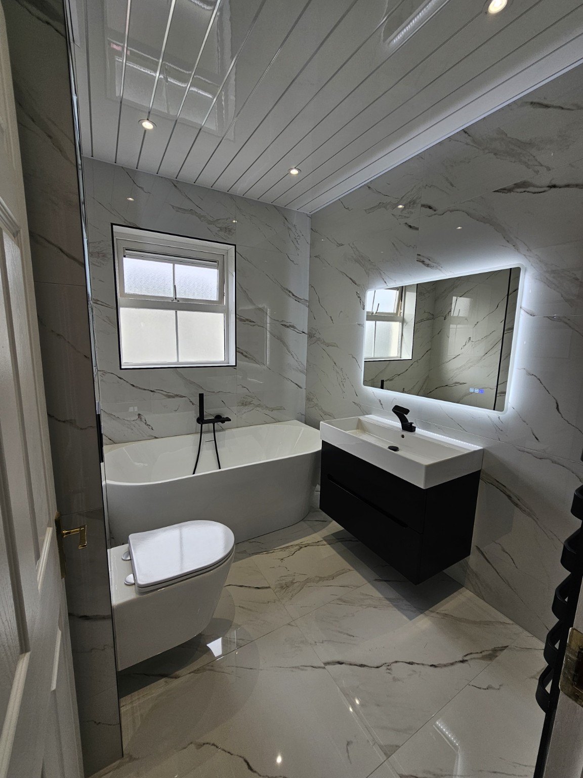 Completed marble-effect bathroom renovation by MT Tileworks